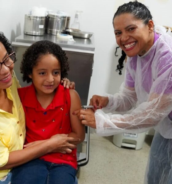 Goiânia e Aparecida antecipam ampliação da vacinação contra gripe - criança no colo da mãe recebendo vacina
