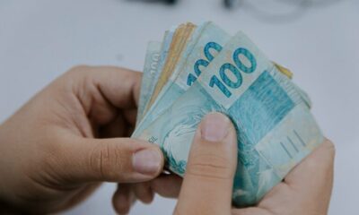 Nota Fiscal Goiana: começa prazo para resgate dos prêmios do sorteio de maio - notas de 50 e 100 reais na mão de uma pessoa