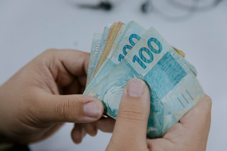 Nota Fiscal Goiana: começa prazo para resgate dos prêmios do sorteio de maio - notas de 50 e 100 reais na mão de uma pessoa