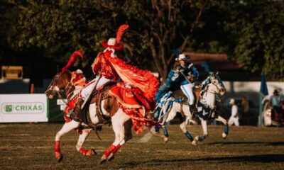 Cavalhadas de Crixás preservam tradição centenária em Goiás - encenação da batalha entre mouros e cristãos - cavaleiros em cavalos brancos e vestindo trajes nas cores azul e vermelha